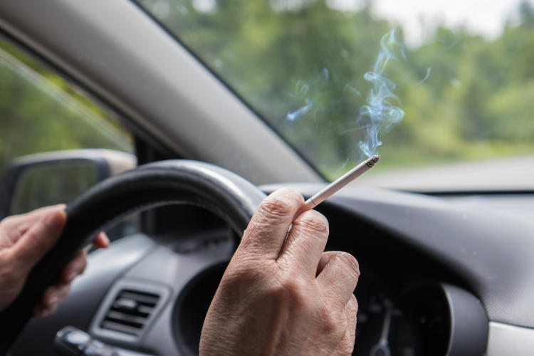 Persona fumando en el coche