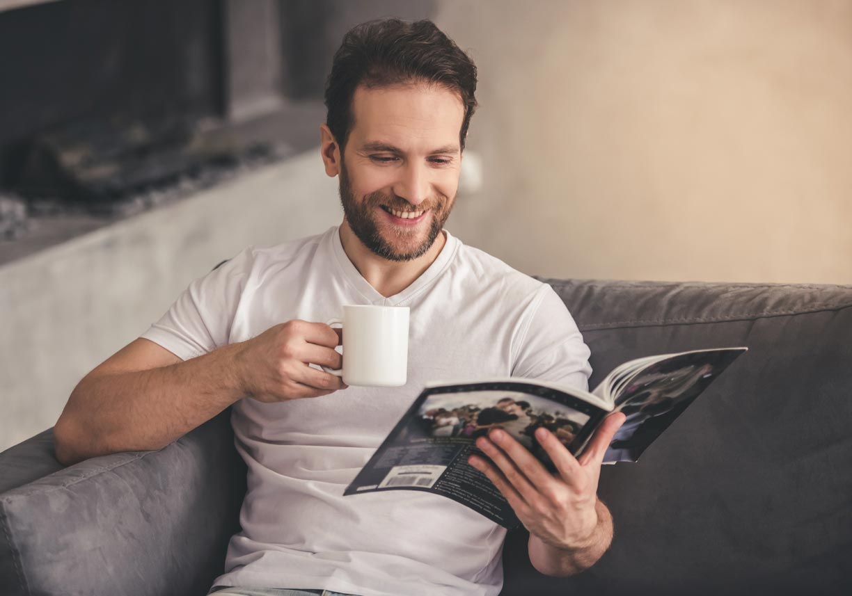 Hombre en casa leyendo un catalogo